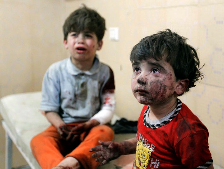 Injured children cry after two barrel bombs were dropped by forces loyal to Syria's president Bashar Assad in Aleppo on May 1, 2014, according to activists.