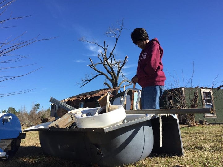 Charlesletta Williams, 75, stands next to the bathtub she sat in during a tornado on Saturday night.