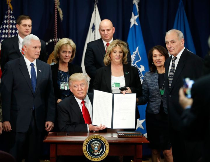 Donald Trump holds up an executive order for immigration actions to build the border wall.