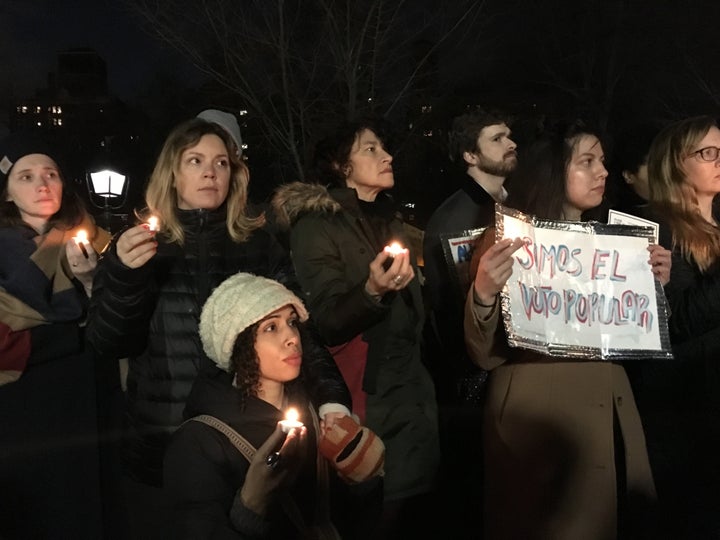 Jessica Maffia, 33, shown at the bottom left, holds a candle at Wednesday evening's protest.