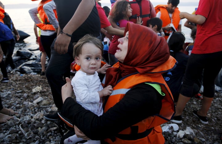 Syrian refugee cries holding her child on the Greek island of Lesbos after crossing a part of the Aegean Sea from Turkey. Sept, 19, 2015.