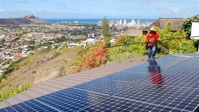 A worker installs solar panels on a roof in Honolulu. More states will encourage the use of renewable energy this year, seeing the economic benefits the industry brings.