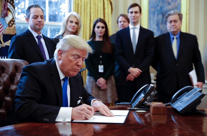 Looking on as President Donald Trump signs an executive order are White House Chief of Staff Reince Priebus, counselor to the President Kellyanne Conway, White House Communications Director Hope Hicks, Senior Advisor Jared Kushner and Senior Counselor Stephen Bannon.