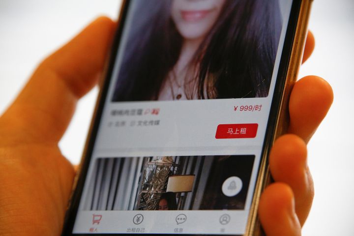 A page of a date-hiring app "Hire Me Plz", which says "rent now for 999 yuan an hour," is shown in this picture illustration in Beijing, China.