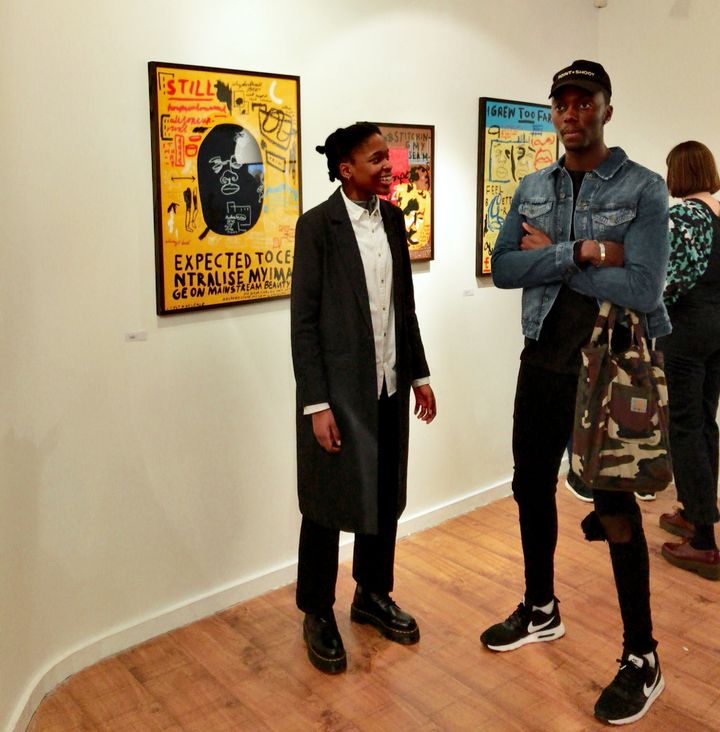 Artists Joy Miessi and Emmanuel Unaji in front of Miessi's series of illustrations on display at Mission Gallery's Ain't I Beatiful? Exhibit in South London