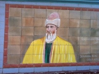 An image of Rumi taken by Brad Gooch appears on a wall leading into Dushanbe, in Tajikistan.