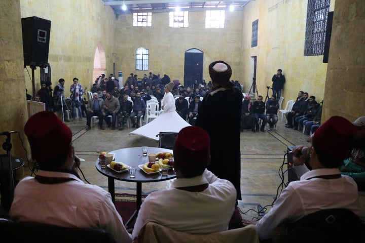 A Syrian whirling dervish (C) performs during a ceremony commemorating the death of 13th-century Sufi poet Rumi, on December 14, 2015 in Bab al-Maqam, a rebel-controlled neighbourhood of the northern city of Aleppo.