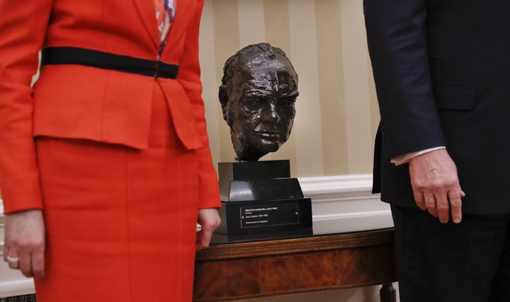 A bust of Churchill sit between Trump and May as they poses for photographs