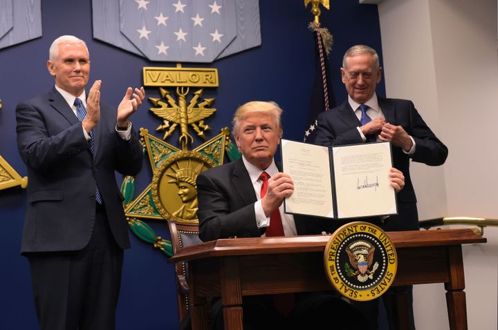 President Donald Trump shows his signature on executive orders alongside Defense Secretary James Mattis and Vice President Muike Pence on January 27, 2016 at the Pentagon in Washington, DC.
