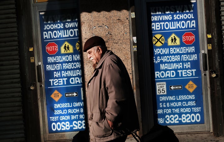 A man walks by signs in Cyrillic text in Brighton Beach, Brooklyn.