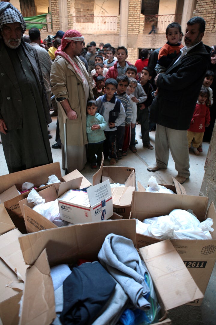 Iraqi refugees wait for presents from US Marines and Iraqi Policemen