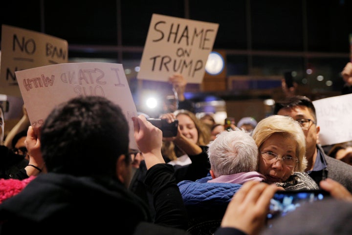 Massachusetts Sen. Elizabeth Warren (D) greets demonstrators at Logan Airport in Boston.