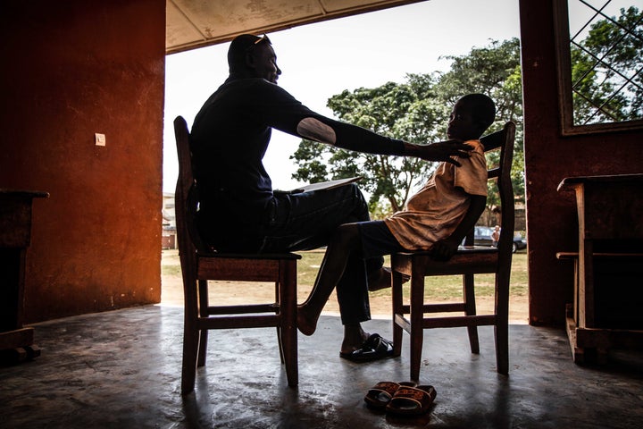 Artist Didier Kassai talks to a boy about why he was forced to live on the streets of Bangui.