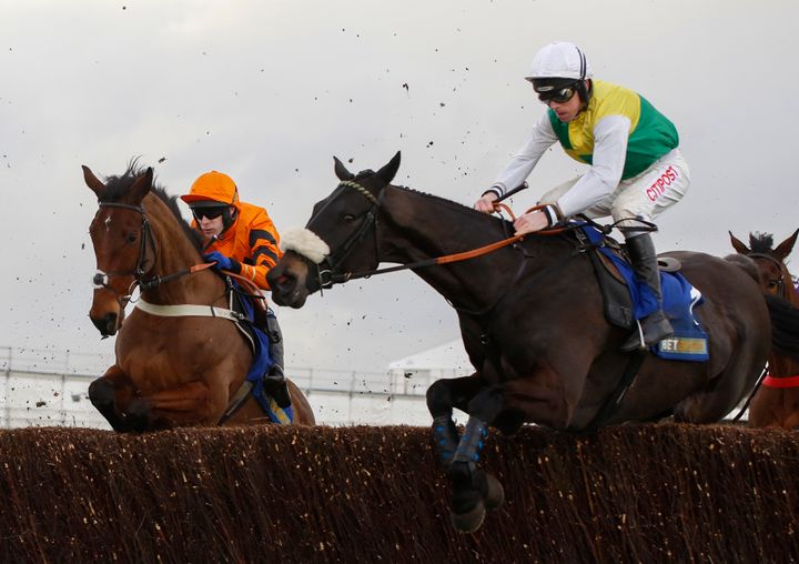 Many Clouds and Leighton Aspell (right) jump an early fence in company with Thistlecrack ridden by Tom Scudamore before going on to win The Betbright Trial Cotswold Chase Race run during Festival Trials Day at Cheltenham Racecourse.