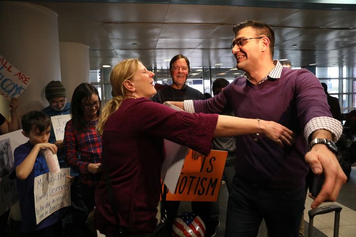Ali Hamedani, right, hugs a supporter after he was held at O'Hare International Airport for three hours and missed his connecting flight to Los Angeles.