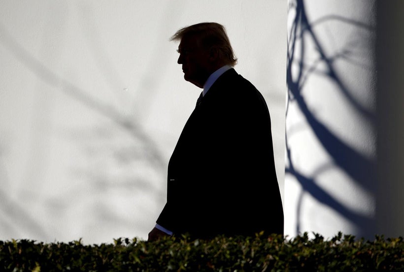 President Donald Trump walks through the Colonnade to the Oval Office after returning to the White House in Washington, Janua