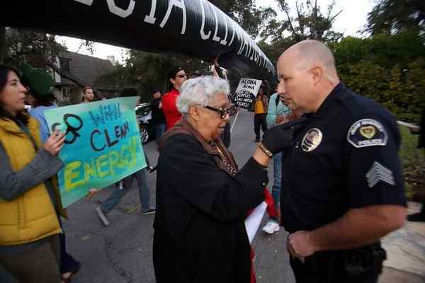 ACCE activist Beverly Roberts talks with San Marino police Sgt. Robert Matthews at protest in front of Wells Fargo CEO Tim Sloan’s mansion. (Photo by James Carbone from Pasadena Star News) 