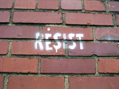 "Resist" spraypainted on brick wall
