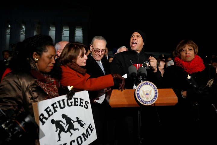 Sen. Cory Booker (D-N.J.), center, speaks at a rally against the travel ban in Washington on Monday.