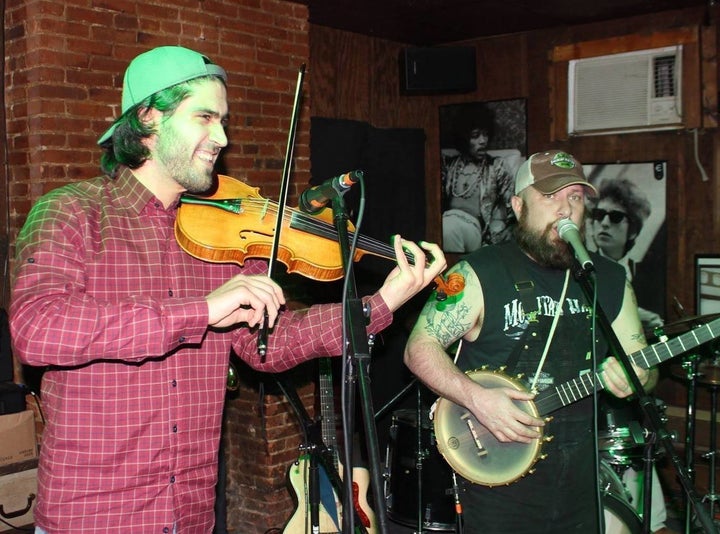 Nashwan Abdullah (left) plays his violin at a live show. Abdullah is unsure of his future after the executive order.