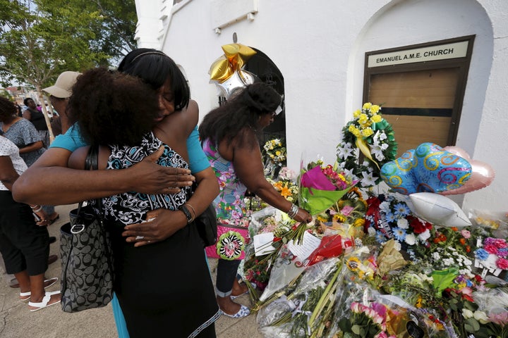 Kumba Mboma and Lucinda Maywood hug at a makeshift memorial outside the Emanuel African Methodist Episcopal Church in Charleston, South Carolina on June 20, 2015, three days after a mass shooting left nine people dead during a bible study.