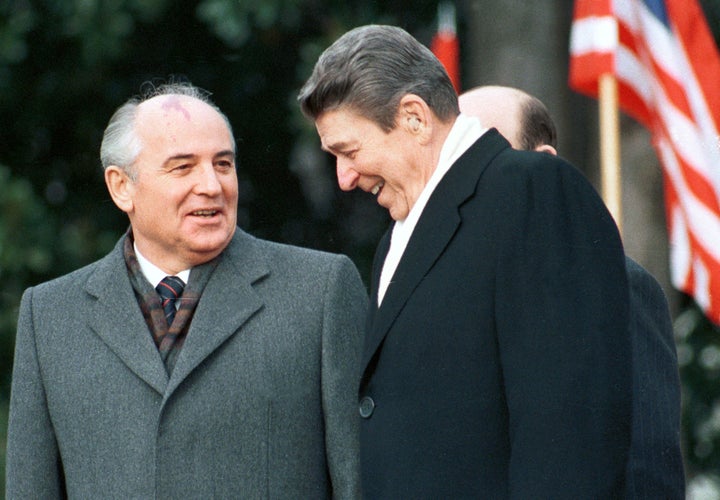 Former U.S. President Ronald Reagan stands with former Soviet leader Mikhail Gorbachev during Gorbachev's arrival ceremony at the White House, December 8, 1987.