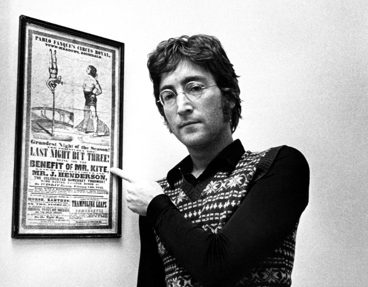 John Lennon posing with the Victorian circus poster