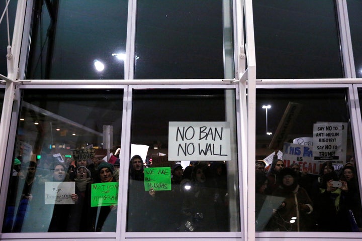 Protesters yell through the windows of Terminal 4 during a protest against Donald Trump's travel ban at John F. Kennedy Inter