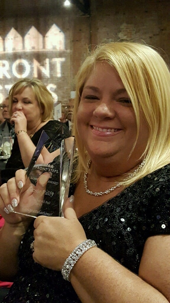 Marine veteran Rosie Palfy, who became homeless after enduring military sexual assault, is shown receiving an achievement award from Front Steps, a transitional housing provider in Cleveland.