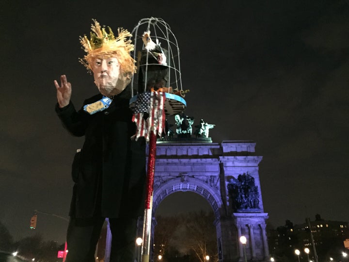 A protestor wearing a Donald Trump costume waves at the crowd of protesters in Grand Army Plaza on Tuesday.