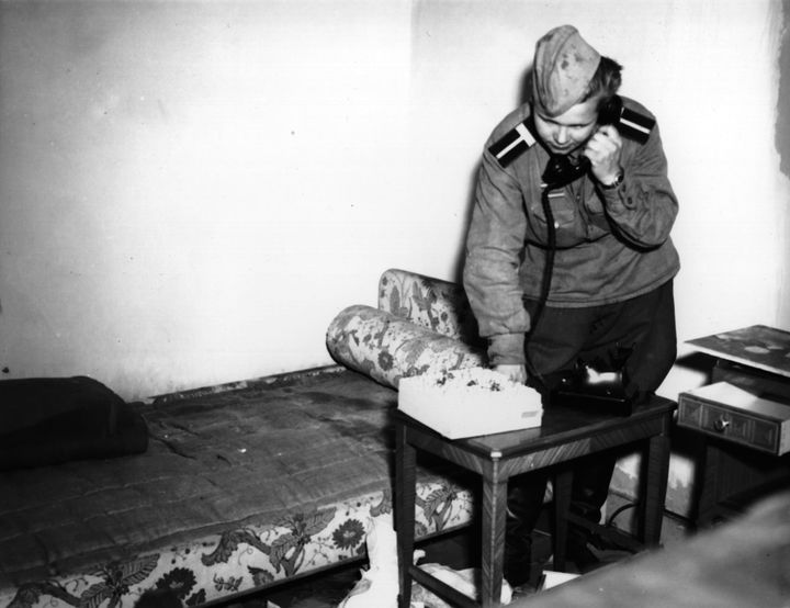 A Russian soldier using Eva Braun's phone in her bedroom in Hitler's shelter on 6 July 1945