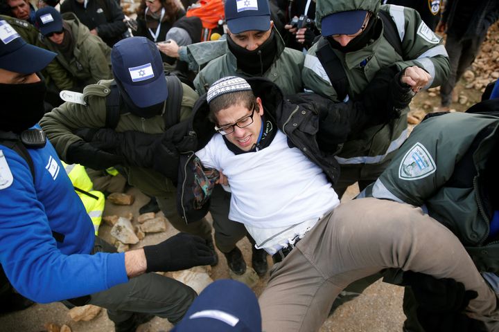 Israeli police remove a pro-settlement activist during an operation by Israeli forces to evict settlers from the illegal outpost of Amona in the occupied West Bank February 1, 2017.