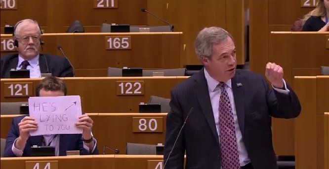 Seb Dance practices what he preaches by holding up a sign in the European Parliament in Brussels accusing Nigel Farage of being a liar.