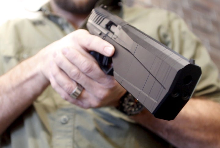 SilencerCo CEO Joshua Waldron holds the new Maxim 9 handgun with a built-in suppressor in West Valley City, Utah, on Feb. 23, 2016.