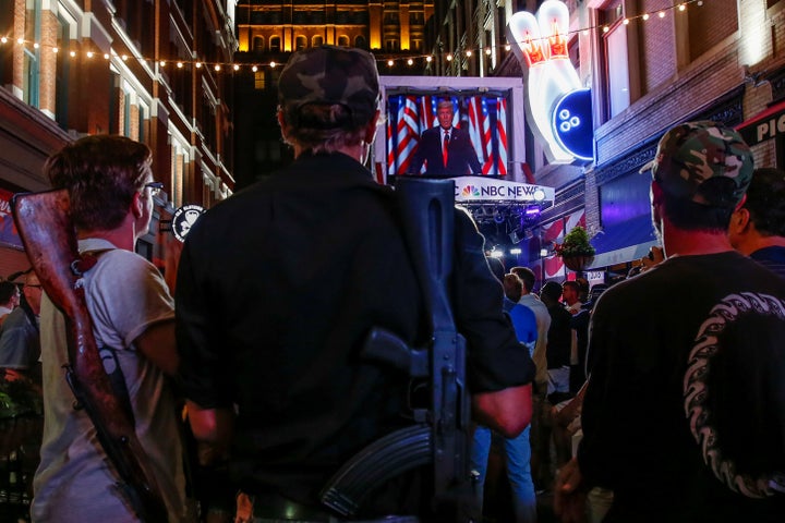 Kevin Kvasnicka and Jesse Gonzales openly carry firearms as they watch Donald Trump speak during the Republican National Conv