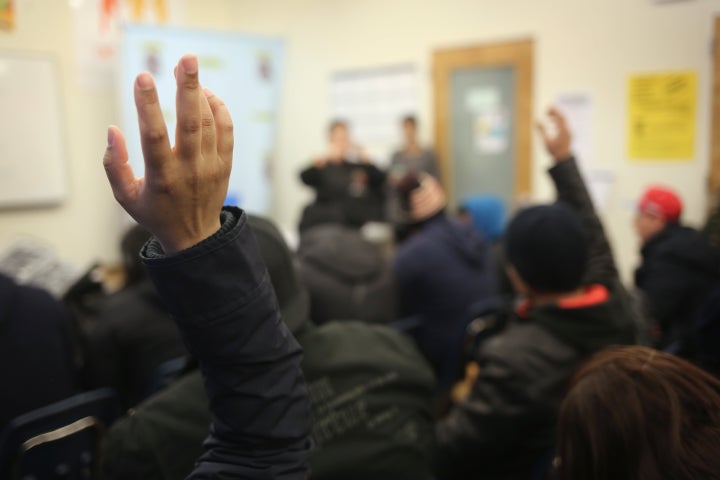 People raise their hands as Immigrants attend a workshop for Deferred Action for Childhood Arrivals (DACA), on February 18, 2015 in New York City.