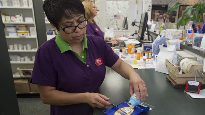 A pharmacist fills a prescription in Sacramento. California has limited insurers’ ability to make midyear changes to covered