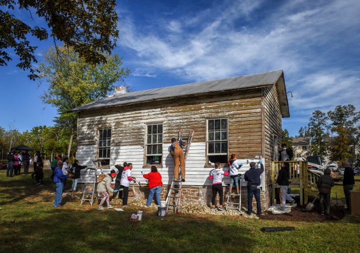 A volunteer group painting the exterior of the Ashburn Colored School, a nineteenth-century schoolhouse recently vandalized w