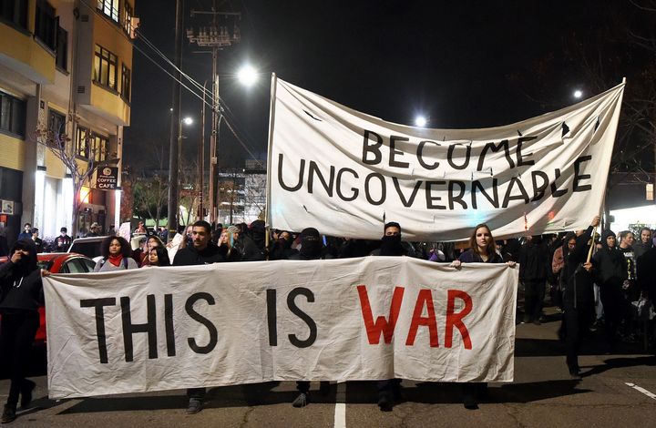 Protesters march with signs in Berkeley, California on February 1, 2017.