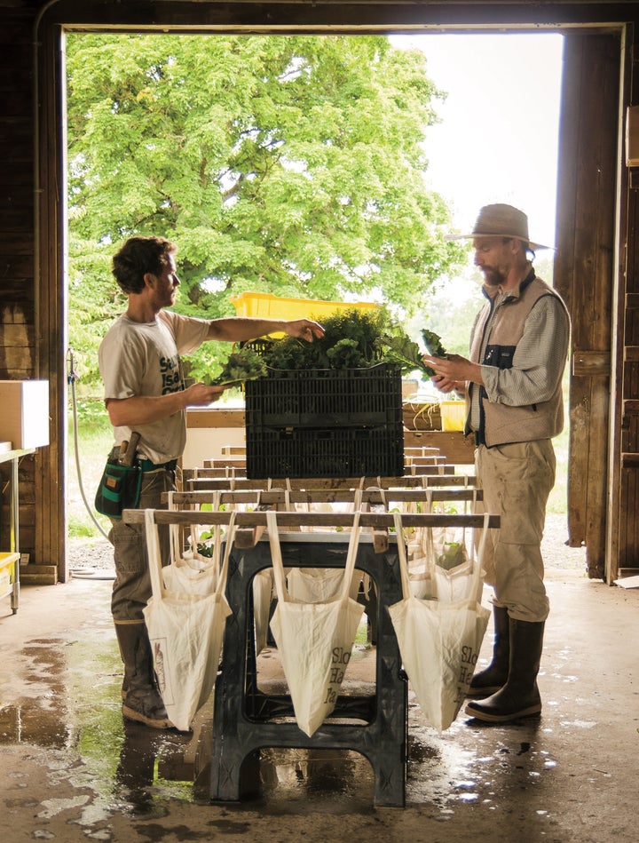 Josh Volk (right) prepares CSA boxes at his farm in Portland, Oregon. Photo from Compact Farms, used with permission from Storey Publishing.