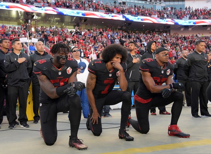 Colin Kaepernick (7) and teammates Eli Harold and Eric Reid kneeled during the national anthem before a game in October.