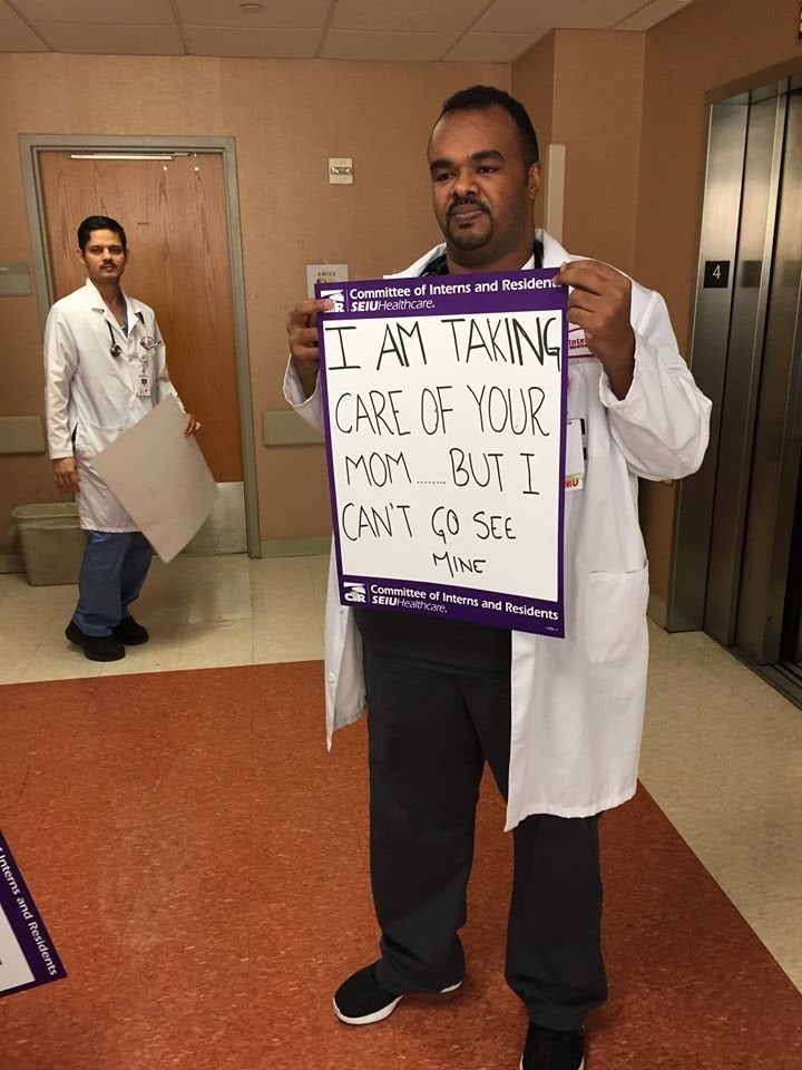 Dr. Mazin Khalid went to medical school with Dr. Kamal Fadlalla and is his friend. He's holding a sign written by another doctor.