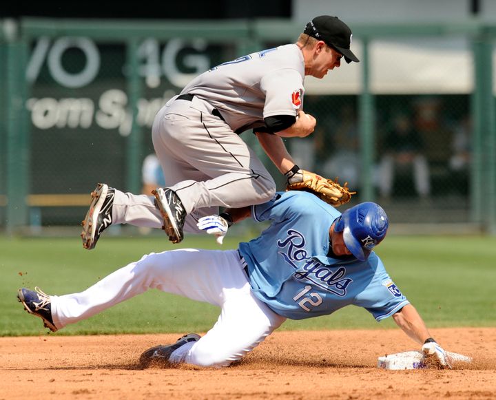 Toronto Blue Jays second baseman Aaron Hill hurdles Kansas City Royals Mitch Maier after Meier broke up the double play in the third inning during their MLB American League baseball game in Kansas City, Missouri, on June 9, 2011.