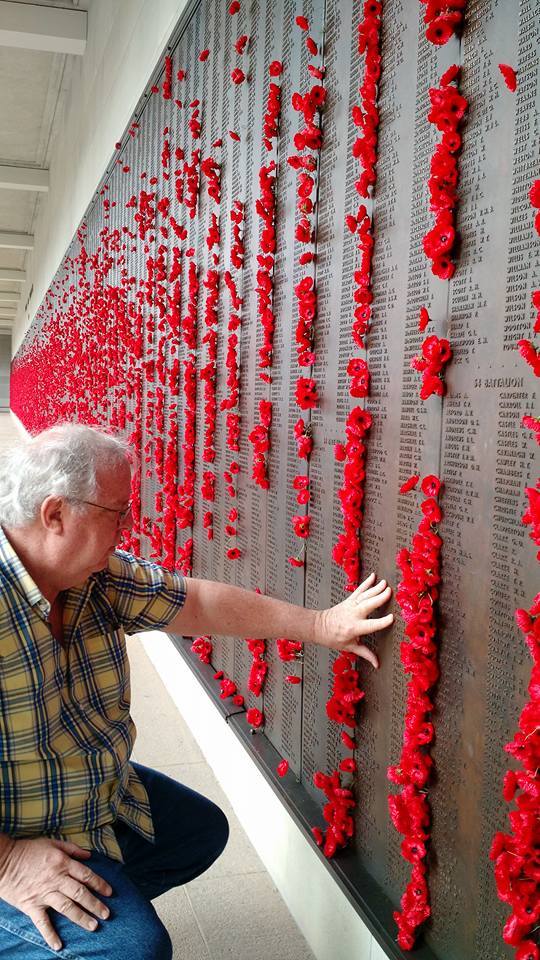 The author touches one of the bronze and engraved walls at the Australian War Memorial in Canberra, honoring more than 102,00