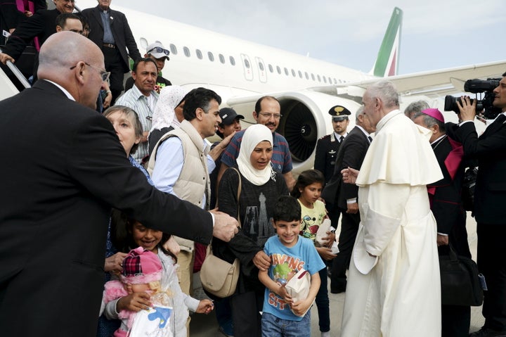 Pope Francis welcomes a group of Syrian refugees after landing at Ciampino airport in Rome following a visit at the Moria ref
