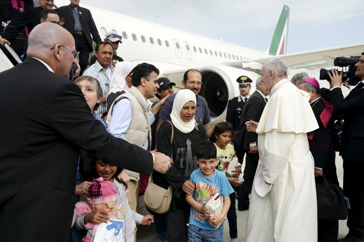 Pope Francis welcomes a group of Syrian refugees after landing at Ciampino airport in Rome following a visit at the Moria refugee camp in the Greek island of Lesbos, April 16, 2016.