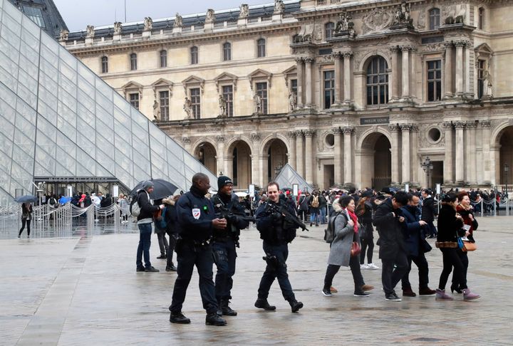 Police officers patrol in front of the Louvre Pyramid in Paris on Saturday