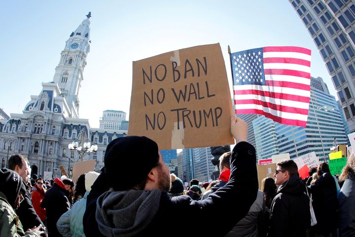 Protester Brandon McTear holds a sign and the American Flag as demonstrators gather to protest against U.S President Donald Trump's executive order banning refugees and immigrants from seven primarily Muslim countries from entering the United States during a rally in Philadelphia, Pennsylvania,