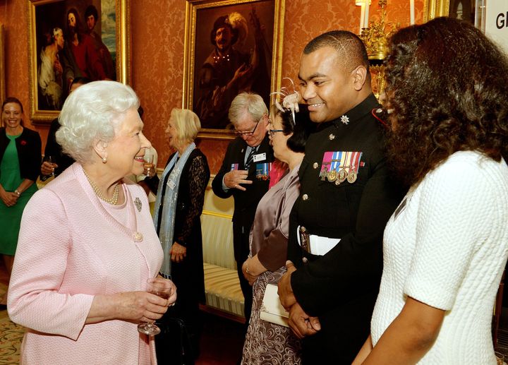 Queen Elizabeth II smiles as she talks to Lance Sergeant Johnson Beharry VC and his wife Mallissa (right) at a reunion reception for the Victoria and George Cross Association, in the picture Gallery of Buckingham Palace, in central London.