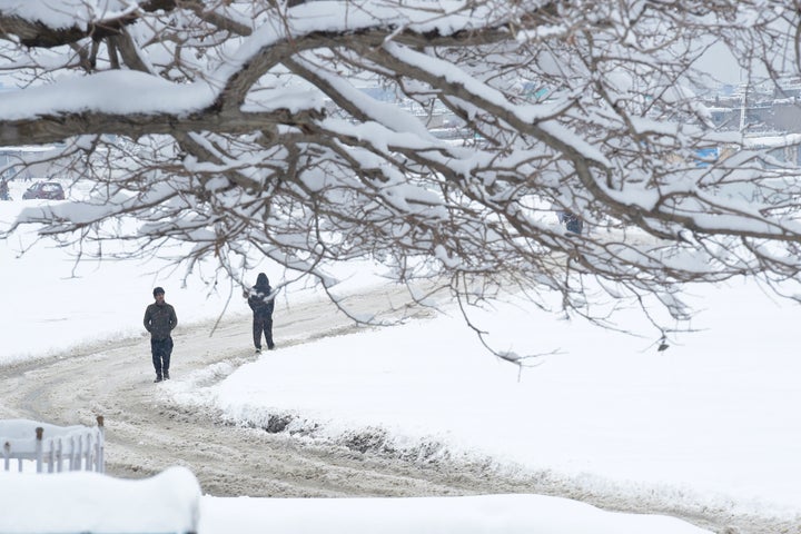 Afghan men make their way down a snow-covered street in Kabul on February 5, 2017.